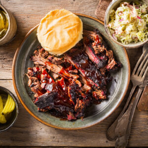 A high-quality, professional food photography shot, overhead view, of the finished slow-cooked beef barbecue. A