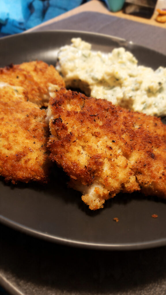 Four-panel collage showing the breading steps for chicken: coating in flour, egg, panko, and frying.